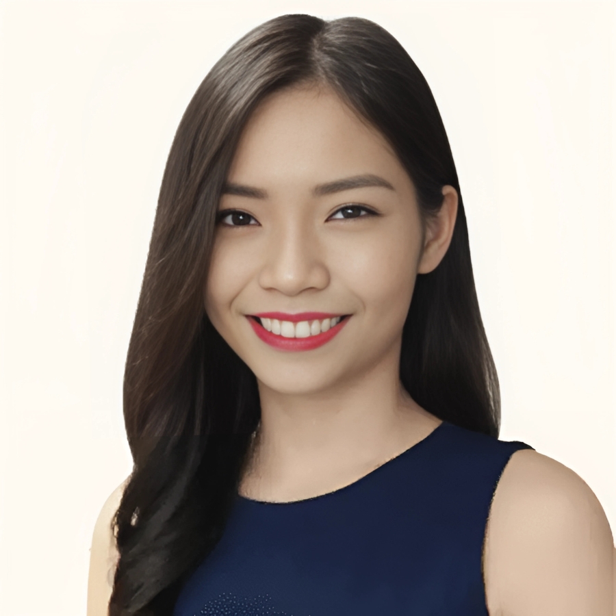 Confident woman smiling, wearing a navy blue top against a light background, representing successful executive coaching at Growth Assembly.